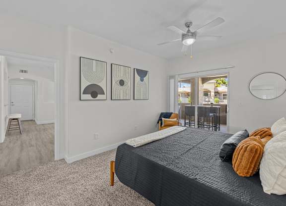 A bedroom with a large bed and a ceiling fan.