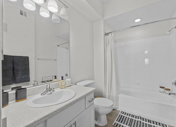 A white bathroom with a sink, toilet, and bathtub.