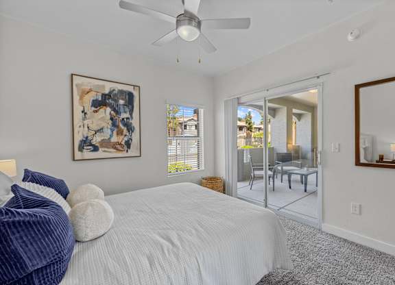 A bedroom with a large bed and a ceiling fan.