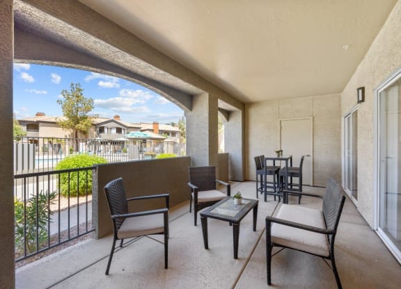 a patio with a table and chairs and a balcony