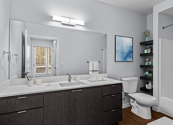 A bathroom with a white countertop and a large mirror.