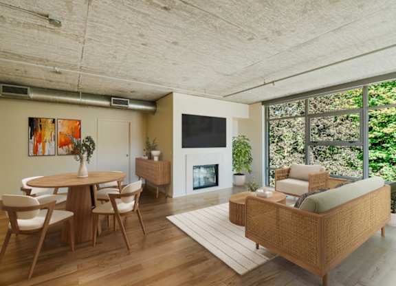 Living room and dining room space with large windows and wood-style flooring at 2121 Belmont apartments in the Buckman neighborhood in Portland, Oregon.