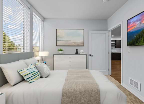 A bedroom with a bed, nightstand, and a painting on the wall.