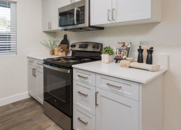 a white kitchen with a stove and a microwave