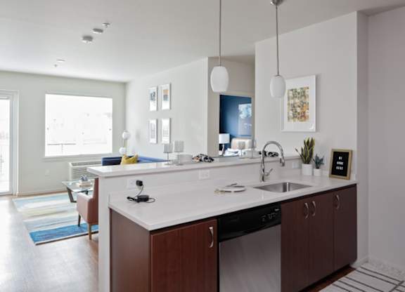 A modern kitchen with a white countertop and dark wood cabinets.