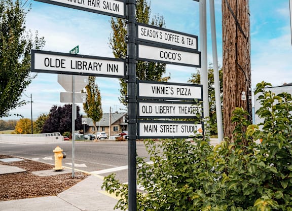 A signpost with multiple directional signs pointing to various local businesses.