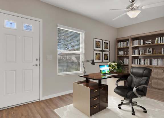 A home office with a desk, chair, and bookshelf.