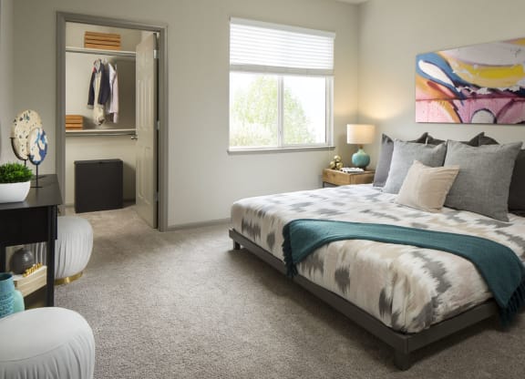 a bedroom with a large bed and a large painting on the wall
