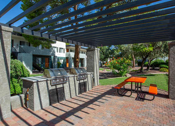 A patio with a table and chairs under a pergola.
