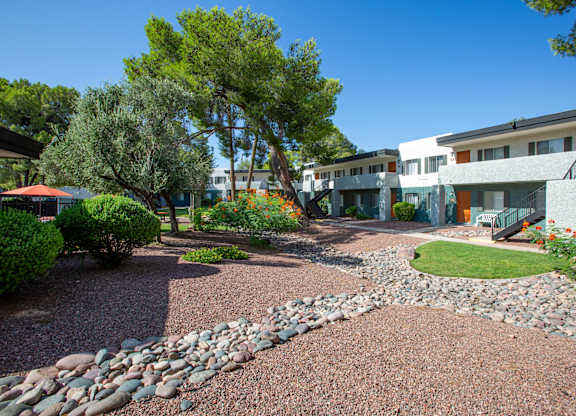 A residential area with a gravel path and a stone wall.