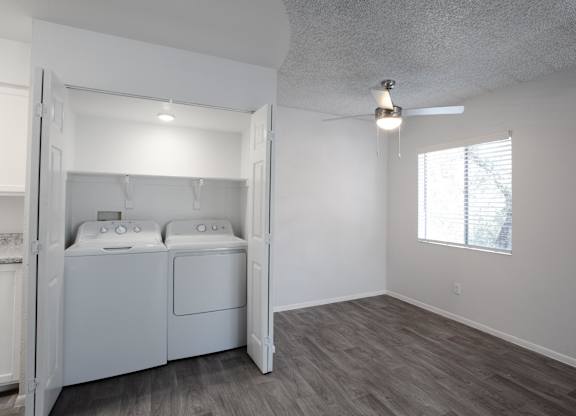A laundry room with a washer and dryer built into a cabinet.