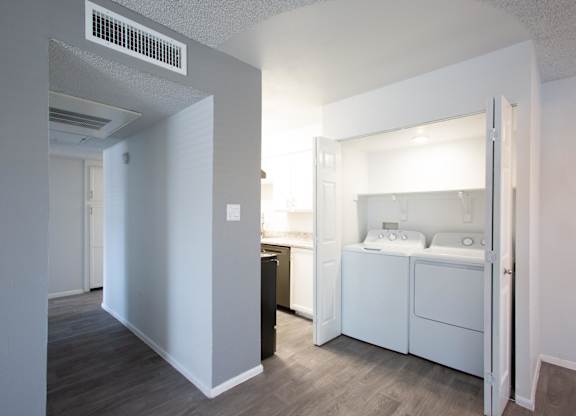 A small bedroom with a washing machine in it.