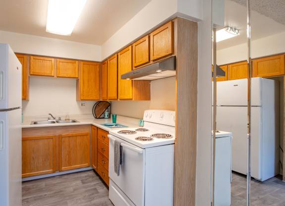 A kitchen with wooden cabinets and white appliances.