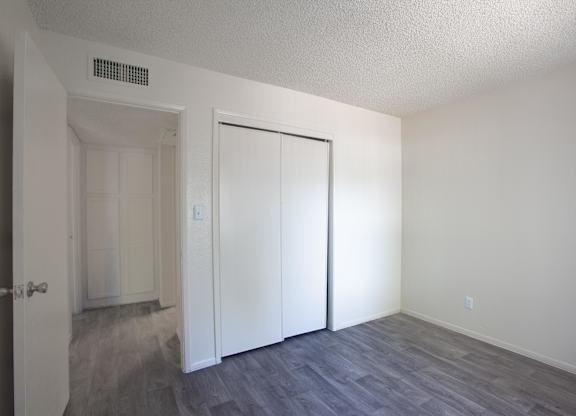 A room with a white door and a grey floor.