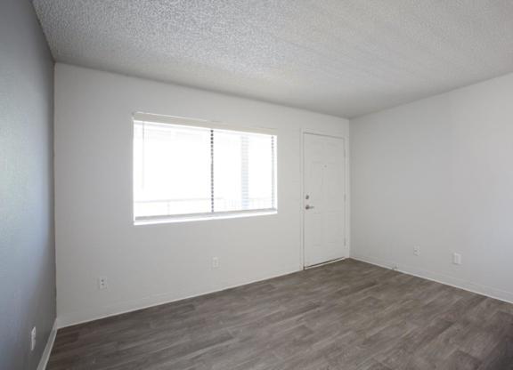 A room with a wooden floor and a window.
