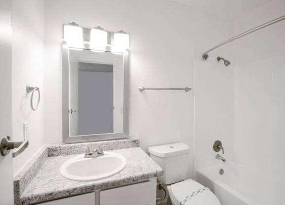 A white bathroom with a sink, toilet, and bathtub.