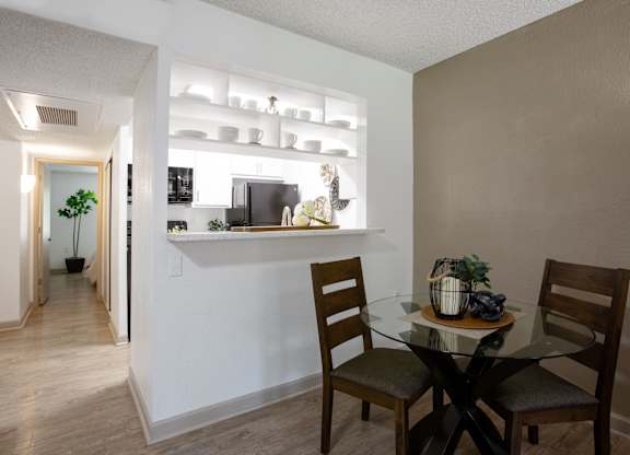 A dining room with a glass table and chairs.