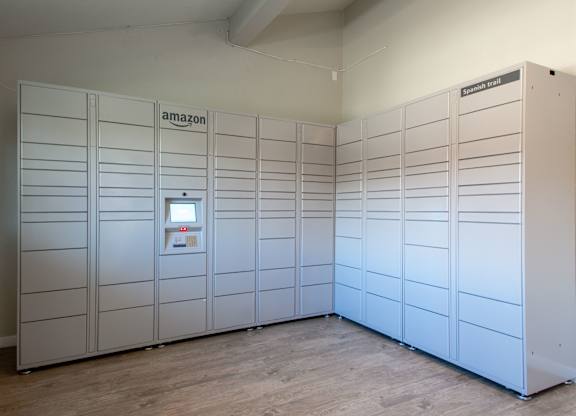 A row of Amazon lockers are lined up in a room.