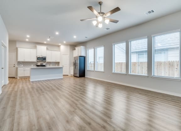 an open living room and kitchen with a ceiling fan