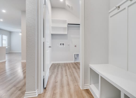 the living room of a new home with white walls and wood floors