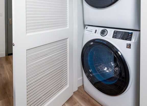 A white washing machine is in a cabinet.