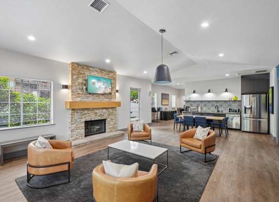 A modern living room with a stone fireplace and a painting above it.
