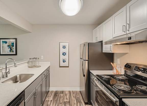 A modern kitchen with a stove, refrigerator, and sink.