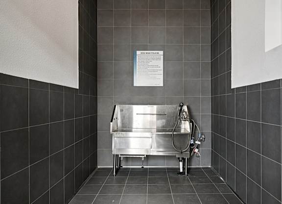 A sink in a public restroom with a sign above it.