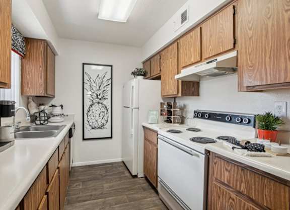 A kitchen with wooden cabinets and a white fridge.