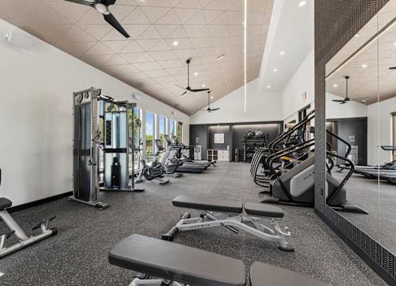 A spacious gym with a variety of equipment including treadmills, weights, and exercise machines.