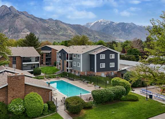 A large house with a pool and mountains in the background.