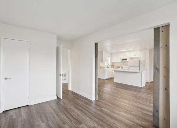 A white interior with a kitchen in the distance.