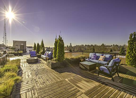 A sunny day on a wooden deck with blue chairs and cushions.