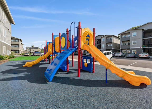 A playground with a blue and yellow slide.