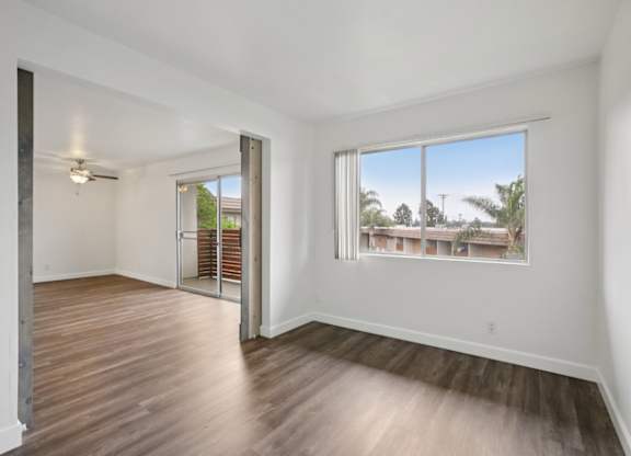 A room with a sliding door and a window overlooking a residential area.