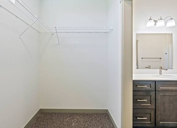 A bathroom with a sink, mirror, and a shelf.