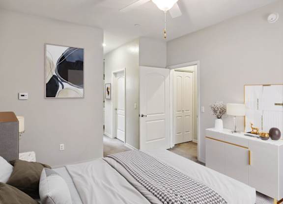 A bedroom with a bed, dresser, and mirror.