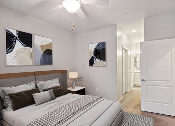 A bedroom with a large bed and a ceiling fan.