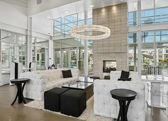 A modern living room with white furniture and a large window.