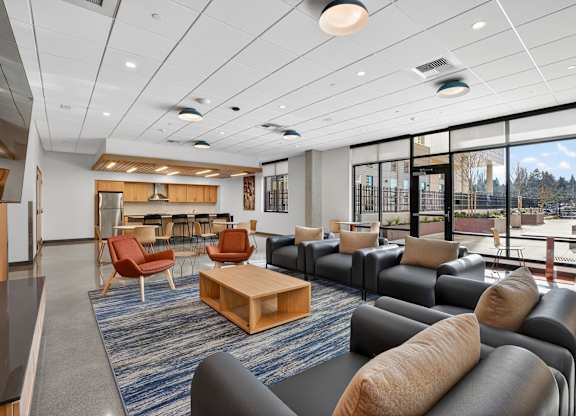 A spacious room with a variety of seating options and a view of the outside.