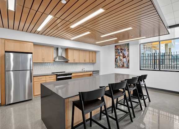 A modern kitchen with a wooden ceiling and a large island.