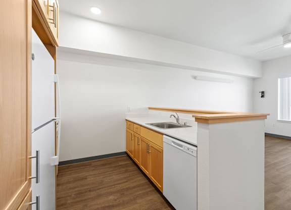 A kitchen with white appliances and wooden cabinets.