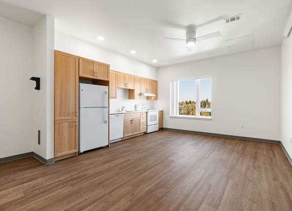 A kitchen with wooden floors and white walls.