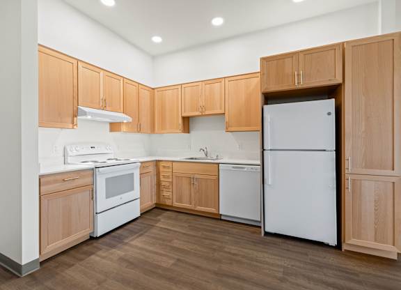 A kitchen with wooden cabinets and white appliances.