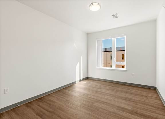 Empty room with wooden floor and white walls.
