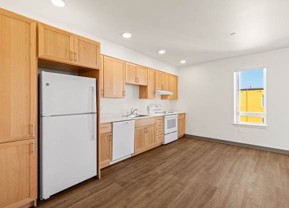 A kitchen with wooden cabinets and a white refrigerator.