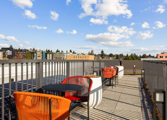 a rooftop deck with chairs and tables and a view of the city
