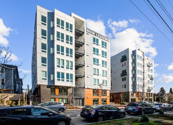 a group of apartment buildings with cars parked in front of them