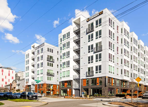 a rendering of a white apartment building on a city street