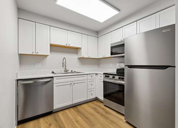 A modern kitchen with stainless steel appliances and white cabinets.